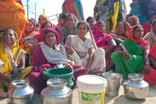 Women block the choke by placing empty pots on the road