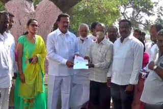 Government whip distributing CM grant-in-aid checks