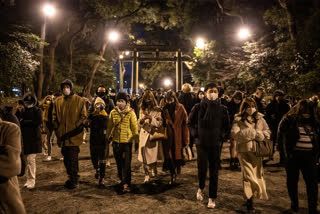 People wearing face masks walk to Meiji Shrine to pray for the new year on January 1, 2021 in Tokyo, Japan.