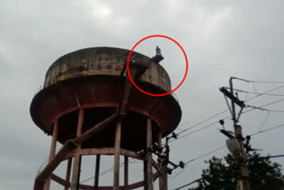 A young man climbing a water tank