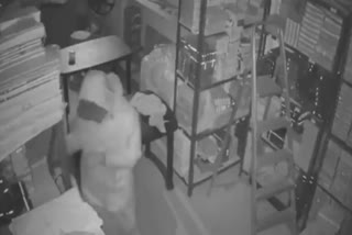 A man dressed in a PPE kit engages in theft in a jewellery shop in Delhi