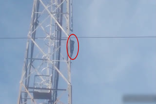 A young man climbing a tower