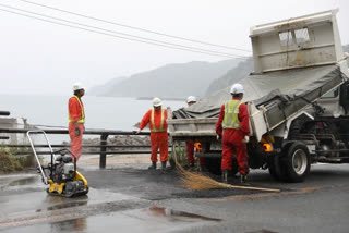 Staff members repair damaged road after an earthquake