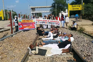 Farmers lying on the tracks