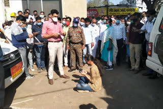 Student sitting on dharna in front of collector’s car