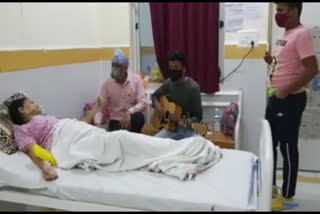 Relatives of Covid patients play guitar in hospital to spread cheer