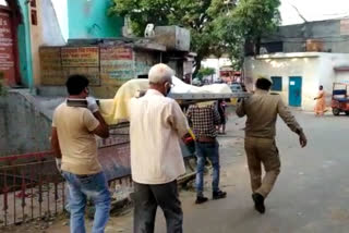 Constable helps carry a bier on his shoulders to the cremation ground