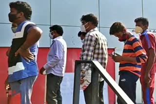 drinkers queue in front of wine shop at kalburgi