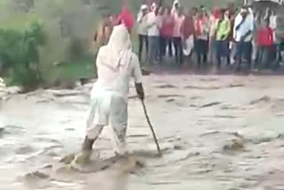 पुराच्या पाण्यात रस्ता ओलांडण्याचा वृद्धाचा प्रयत्न