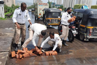 वाहतूक पोलिसांनी बुजवला रस्त्यावरील खड्डा