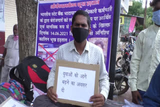 man sitting on hunger strike in front of bank