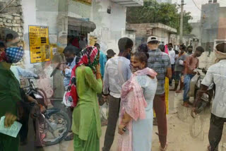 people getting free ration after waiting for hours at ration shops in vikaspuri delhi