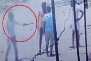 young man pointing gun at victim