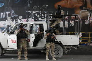 Police stand guard under an overpass in Port-au-Prince