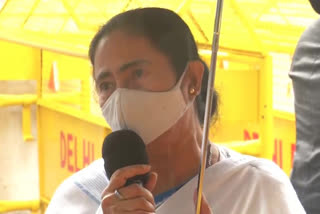 Mamata Banerjee holding umbrella at press conference in Delhi