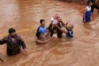 Volunteers form human chain amidst gushing flood water to rescue toddler