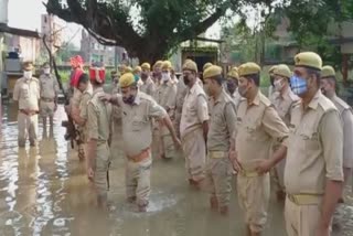 घुटनों तक भरे पानी के बीच सलामी देती पुलिस.