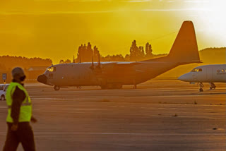 Military personnel walk by Belgian military planes, used as part of an evacuation from Afghanistan, upon arrival at Melsbroek Military Airport in Melsbroek, Belgium, Friday, Aug. 27, 2021. (