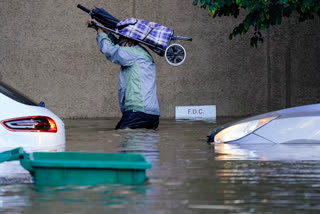 A person walks in floodwaters in Philadelphia, Thursday, Sept. 2, 2021 in the aftermath of downpours and high winds from the remnants of Hurricane Ida that hit the area