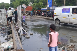 Sewer dirty water flowing on the main road of Okhla industrial area delhi