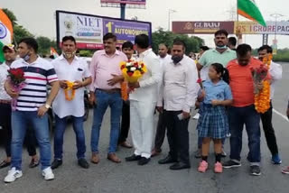 People standing to welcome Praveen Kumar