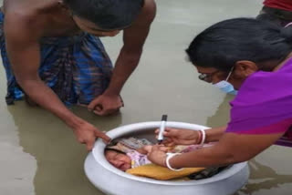 man brings infant in utensil for polio vaccination