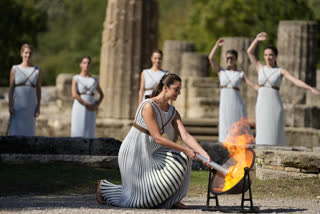 Greek actress Xanthi Georgiou, playing the role of the High Priestess, lights the torch during the lighting of the Olympic flame at Ancient Olympia site, birthplace of the ancient Olympics in southwestern Greece