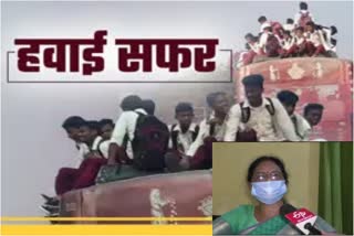 school children traveling on roof of bus in giridih