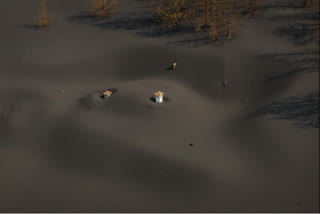 La Palma volcano buries homes and fields in ash