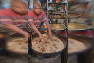 man dips his hand in boiling hot oil while making fried chicken