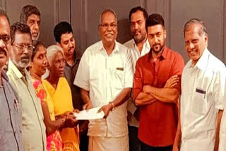 Actor Surya presents a cheque