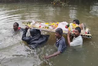 இறந்தவர் உடலை வெள்ளத்தில் சுமந்து செல்லும் அவலம்