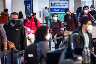 Masked airline travelers wait to go through security at Ronald Reagan Washington National Airport in Arlington, Va., earlier this month.