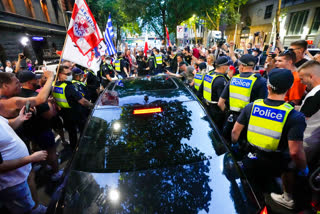 Fans of Serbian Novak Djokovic surround a car as it leaves the offices of lawyers following his court win ahead of the Australian Open in Melbourne