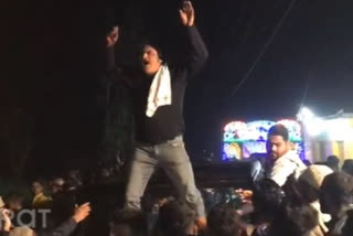 Congress supporter climbs up a car to celebrate Anupama Rawat's victory from Haridwar rural