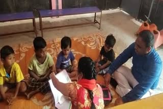 Dr. Ilaiyaraaja T sitting on the ground among the children