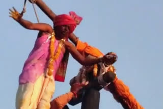 devotees hangs on a 30 feet high pillar in ujjain