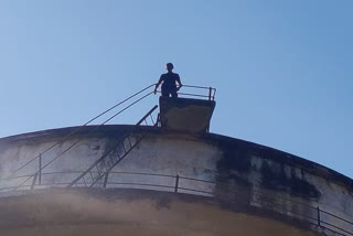 young man climbing into water tank