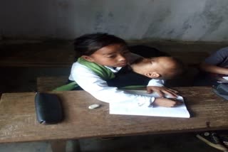 Manipur Girl attending classes with her younger sibling on lap  അനിയത്തിയെ മടിയിലിരുത്തി ക്ലാസ്സ് കേട്ടു  മണിപ്പൂര്‍  viral in social media