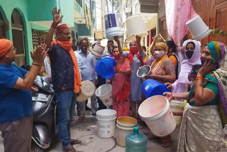 बाल्टी लेकर प्रदर्शन करती महिलाएं