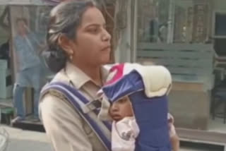 Woman constable discharges police duties carrying her toddler