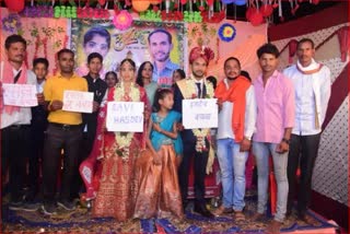 After the varmala in Bilaspur the bride and groom stood with the poster the message of saving the Hasdev forest