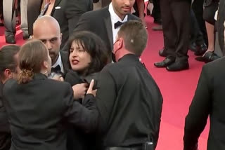 Topless woman storms Cannes  protest against sexual violence in Ukraine  protest against sexual violence against women in Cannes  ನಮ್ಮನ್ನು ಅತ್ಯಾಚಾರ ಮಾಡುವುದನ್ನು ನಿಲ್ಲಿಸಿ ಎಂದು ಕೇನ್ಸ್​​ನಲ್ಲಿ ಮಹಿಳೆ ಪ್ರತಿಭಟನೆ  ಕೇನ್ಸ್​ನಲ್ಲಿ ಮಹಿಳೆ ಅರೆಬೆತ್ತಲೆ ಪ್ರತಿಭಟನೆ  ಉಕ್ರೇನ್‌ನಲ್ಲಿ ಮಹಿಳೆಯರ ಮೇಲಿನ ಲೈಂಗಿಕ ದೌರ್ಜನ್ಯ ಕಂಡಿಸಿ ಅರೆಬೆತ್ತಲೆ ಪ್ರತಿಭಟನೆ