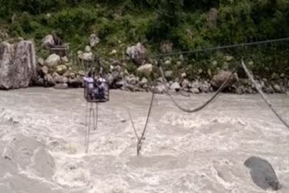 People crossing Bhagirathi river with shabby trolley ropes