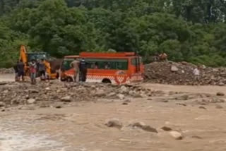 Stuck bus in the middle of Dhangarhi drain rescued by JCB