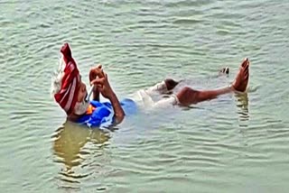 Ashok Kumar Singh of Vaishali plays flute with swimming