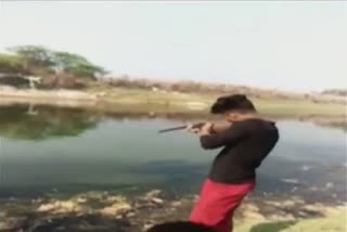Youngman hunts fish with gun in Pratapragh district of UP