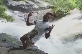 young man fell in the waterfall while posing