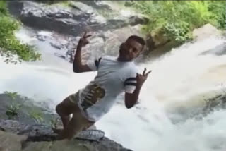 young man fell in the Pullaveli waterfall  young man fell in the Pullaveli waterfall viral video  Accident at Pullaveli waterfall Dindigul  accident at waterfalls  accident while taking videos  accident while taking photographs  വീഡിയോയ്‌ക്ക് പോസ് ചെയ്യുന്നതിനിടെ അപകടം  ഫോട്ടോ എടുക്കുന്നതിനിടെ അപകടം  വീഡിയോയ്‌ക്ക് പോസ് ചെയ്യുന്നതിനിടെ പുല്ലവേലി വെള്ളച്ചാട്ടത്തില്‍ വീണ് യുവാവ്  വെള്ളച്ചാട്ടങ്ങളിലെ അപകടം  പുല്ലവേലി വെള്ളച്ചാട്ടത്തില്‍ വീണ് അപകടം