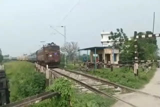 Loco pilot alights from train to close gate of railway level crossing in Bihar's Siwan